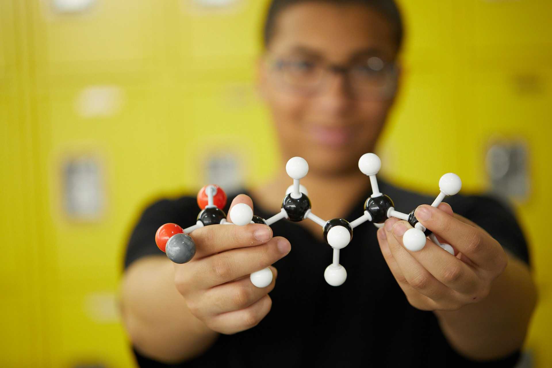 a student holding a model of a molecule