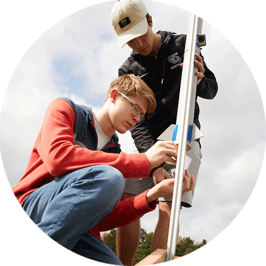 two students preparing a model rocket