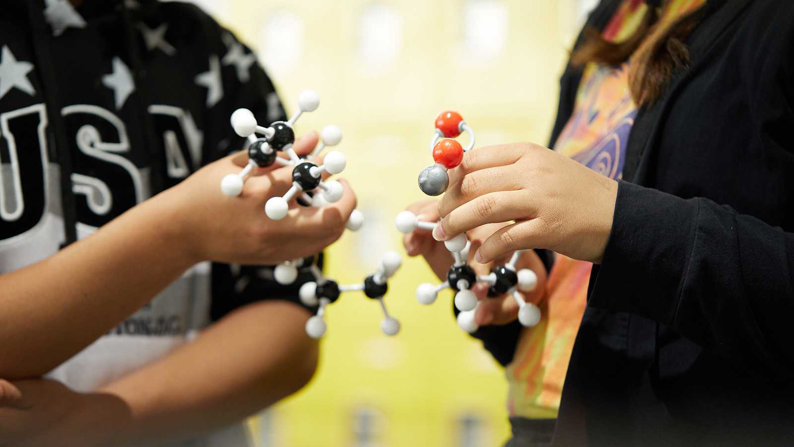 a student holding the model of a molecule