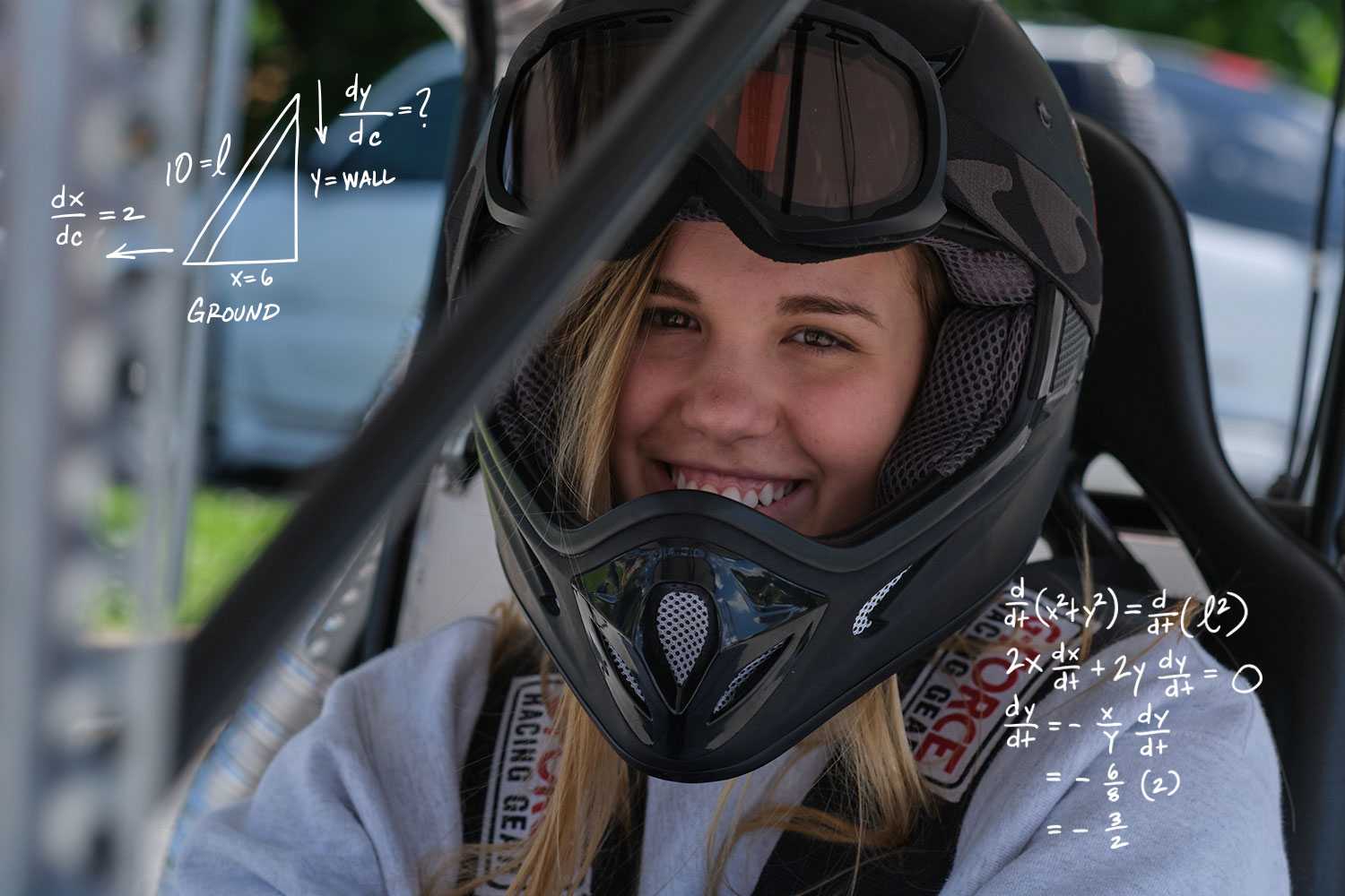 a student driving a go kart wearing a helmet
