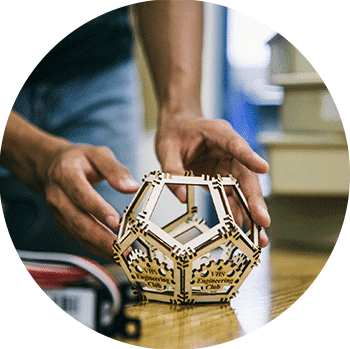 a student building a small wooden model of a shape