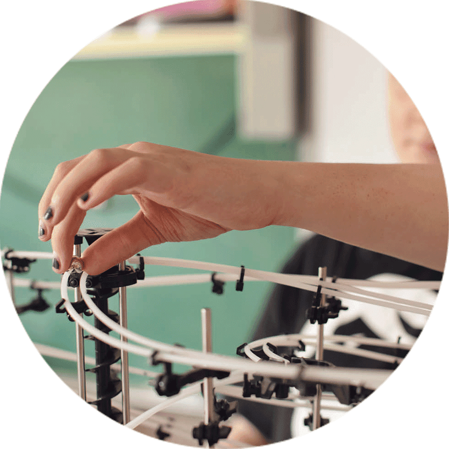 a hand placing a ball bearing on a track